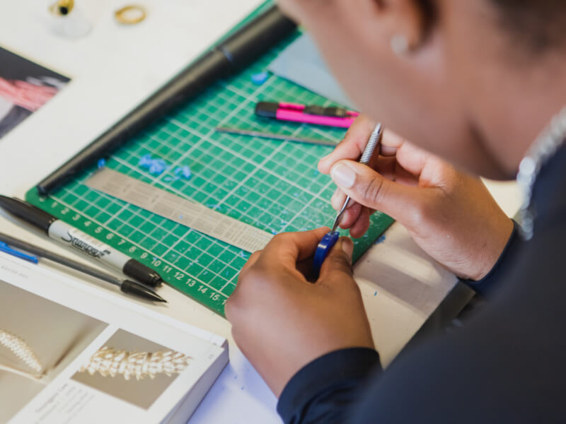 A woman carving a DIY jewellery mould